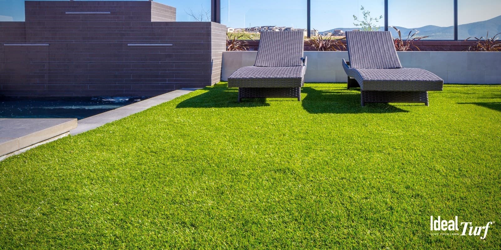 Two lounge chairs on rooftop artificial grass installed by Ideal Turf